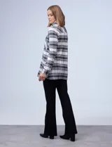 Camisa de tejido soft con diseño de cuadros en tonos beige, cuello con solapa y abertura central con botones.