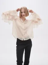Camisa color crudo de poliéster con cuello mao y mangas largas con volados.