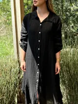 Vestido camisero amplio y largo de lino color azul, con botones de nácar, cuello camisero y bolsillos laterales.