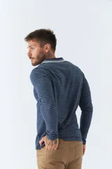 Polo de manga larga a rayas azul marino y blancas, con cuello clásico y logo bordado en el pecho. Corte regular.