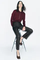 Jeans de tiro alto color negro, corte slim fit y bootcut, con cinco bolsillos y cierre frontal con cremallera y botón.