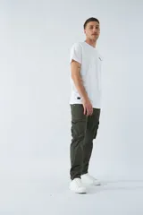 Pantalón cargo color marrón, corte slim, con cierre y botón en la cintura, pasacintos y bolsillos cargo con botones.