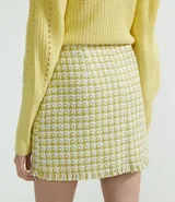 Falda corta de tweed con cierre frontal de botones.