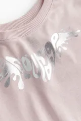 Remera corta rosa de algodón, con cuello redondo y estampado plateado en el frente.