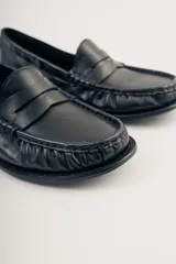 Mocasines de cuero negro con detalle de antifaz.
