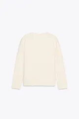 Chaqueta color crema de tejido de punto liso, con cuello redondo, manga larga, bolsillos delanteros de plastrón y cierre frontal con botones dorados.