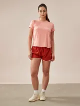 Remera de poliéster color coral, de corte clásico y mangas cortas.