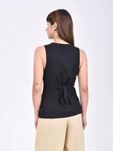 Chaleco color crudo con botones frontales y corte en V. Sin mangas.