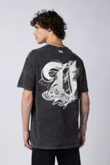 Remera negra con efecto gastado, corte holgado y estampa frontal con la frase 'Astral Energy' en blanco.