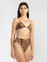 Conjunto de bikini con estampado animal print en tonos marrón y negro. El corpiño es de triángulo con tirantes finos y la bombacha es de tiro alto.