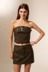 Top strapless de eco-cuero color marrón oscuro, con hebilla decorativa en el frente y corte ajustado al cuerpo.