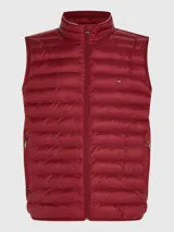 Chaleco acolchado rojo con cierre de cremallera, cuello alto y dos bolsillos laterales con cremallera. Tiene logo de Tommy Hilfiger bordado en el pecho.