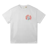 Remera de manga corta color blanco jaspeado, con cuello redondo y un pequeño estampado circular en el pecho izquierdo. El estampado presenta texto en rojo y una figura mitológica en tonos celestes y grises.