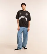 Remera negra de poliéster con corte oversized, cuello redondo, manga corta y estampa frontal con lettering y logo de Notorius BIG.