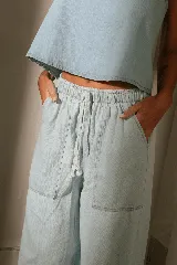 Conjunto de denim compuesto por un top corto con breteles anchos y un pantalón palazzo con cintura elastizada y bolsillos laterales.