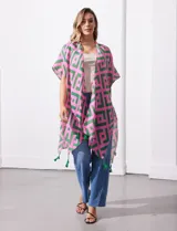 Kimono tejido con estampado geométrico en tonos rosa y verde, con terminación de ruedo con borlas verdes.