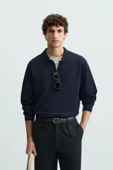 Polo de manga larga color negro, tejido en hilatura con mezcla de algodón y seda, de corte regular fit, con cuello solapa y cierre frontal de botonadura.
