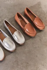 Mocasines de cuero color marrón claro con costuras a la vista.