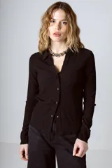 Camisa negra de tejido texturizado con cuello camisero, manga larga y cierre frontal con botones.