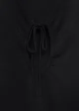 Top negro de punto fino, sin mangas, con cuello en V y detalle de lazo en el escote.