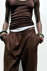 Pantalón bombacho color beige de lino, con cintura elástica, bolsillos frontales y bolsillos de parche en la espalda.