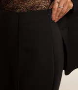 Pantalón de viscosa con corte flare, cintura alta, sin estampa, con frisos delanteros y abertura lateral en el bajo.