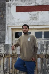 Remera negra de algodón con cuello redondo y mangas cortas. Estampado en el frente de una mano haciendo el signo de la paz.