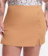 Short pollera color ocre con corte sastrero, botones delanteros forrados y pequeña abertura en la pierna.