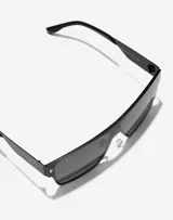 Lentes de sol Hawkers modelo Long Island, unisex, con montura cuadrada negra y lentes grises.