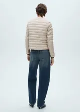 Campera acolchada color beige con cierre frontal y cuello redondo.