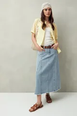 Falda midi de denim celeste con costuras verticales y ruedo desflecado.