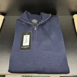 Buzo azul marino de punto con medio cierre metálico, cuello alto y logo de la marca Ganbaru bordado en el pecho. Confeccionado en Uruguay.