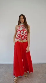 Top de seda estampado en blanco y rojo, con cuello halter y lazo en la espalda.