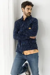 Camisa de franela escocesa con cuello, cierre frontal con botones, dos bolsillos con solapa abotonada en el pecho y corte recto.