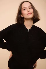 Campera con cierre frontal, de tejido con ondas y rayas horizontales verdes, rojas y negras.