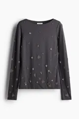 Remera gris de manga larga en punto elástico con diseño de cuentas de vidrio pequeñas. Modelo entallado con escote bote y ribetes sobrehilados.