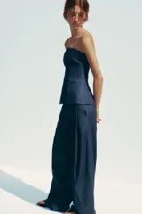 Pantalón de denim azul con pinzas delanteras, tiro medio, cintura con trabillas, bolsillos laterales y traseros.