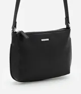Cartera bandolera pequeña de poliuretano color negro, con cierre de cremallera y asa transversal regulable.