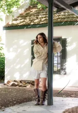 Camisa celeste con estampado de flores blancas, corte clásico, cuello camisero y mangas largas abullonadas.