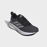 Championes de running Adidas Runfalcon 5 TR, color negro con tres franjas laterales plateadas reflectantes. Posee mediasuela Cloudfoam blanca y suela exterior Adiwear negra con tacos para agarre en terrenos irregulares.