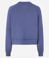 Buzo deportivo femenino confeccionado en microfibra color azul, con cuello redondo, mangas raglán largas y recortes.
