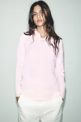 Jersey de punto color borgoña, con cuello redondo, manga larga y bajo con aberturas laterales.