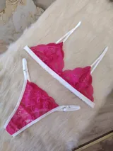 Conjunto de lencería fucsia de encaje floral, compuesto por un corpiño triangular sin aro y una tanga con tiras finas blancas.