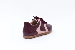 Zapatillas Magnolia de cuero color borgoña con detalles en rosa pastel y suela color caramelo.