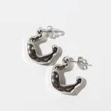 Par de aros tipo argolla gruesa de acero plateado con forma irregular.