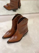 Botas cortas de cuero color marrón con punta fina, taco cuadrado y apliques de tachas metálicas.