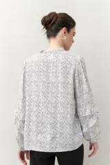 Camisa de manga larga estampada en azul y blanco, confeccionada en viscosa, con cuello mao con pequeño volado y mangas con leve volumen.