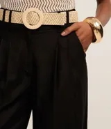 Pantalón wide leg verde oliva de cintura alta, confeccionado en viscolino, con trabillas en la cintura, cierre tradicional y pliegues. Incluye cinturón de rafia artificial.