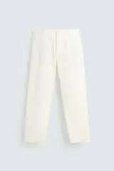 Pantalón chino color crema, de corte recto y largo a la altura del tobillo.