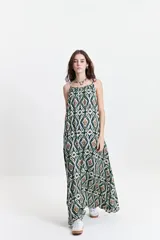 Vestido largo de poliéster con estampado geométrico en tonos verde, marrón y blanco. Tiene breteles finos y escote redondeado.